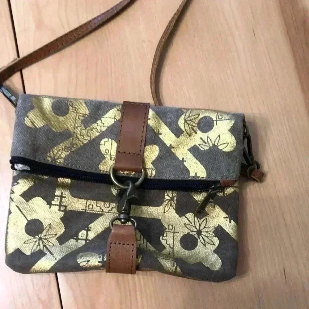 Mona B. Fold over crossbody bag. Tan/gold design.